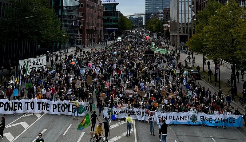 Demonstrators at Climate Strike hold signs demanding climate justice Hamburg Germany